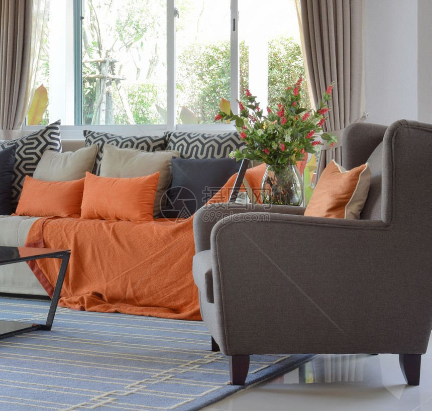 现代客厅设计有棕色和橙沙发黑枕头图片
