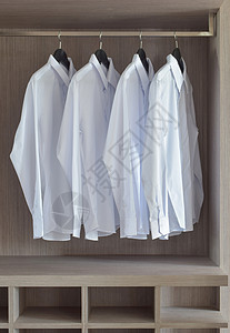 温暖木制衣柜中的古典白色衬衫图片