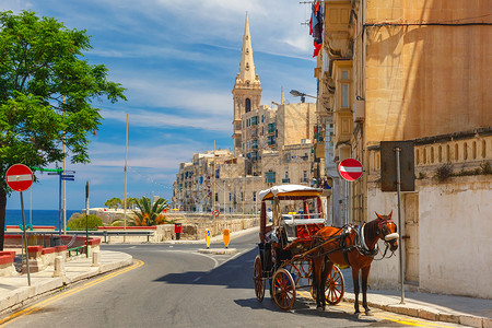 马耳他瓦莱塔老城街上旧和圣保罗卡斯柯的马车耳他瓦莱塔的圣公会支持天主教圣公会背景图片