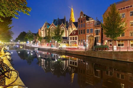 阿姆斯特丹红灯区DeWalllen夜间红灯区DeWalllen运河OudezijdsWirburgwal和Oude教堂及其镜像反背景图片