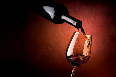 棕色背景的葡萄酒倒在杯里背景图片