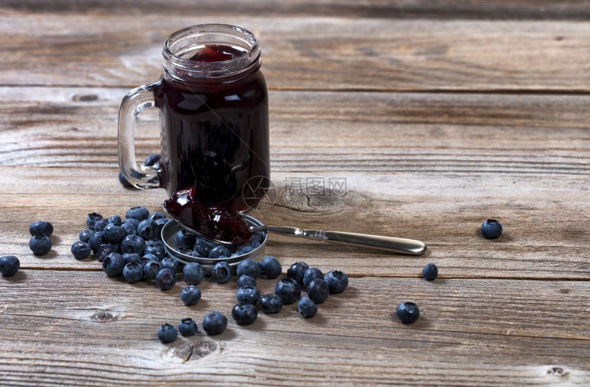 蓝莓果酱汤匙新鲜成熟的蓝莓和生锈木材背景的罐子图片