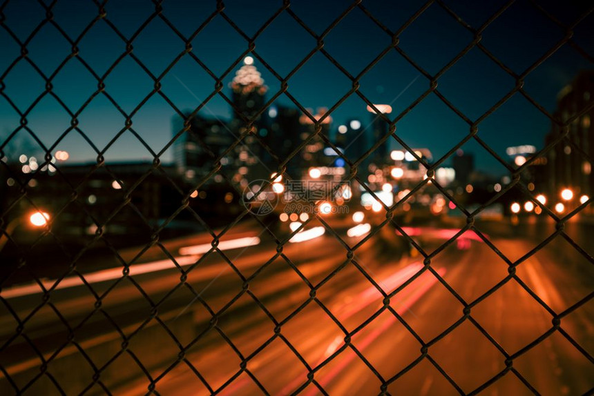 穿过铁丝网栅栏的城市天线抽象模糊的城市景色背图片