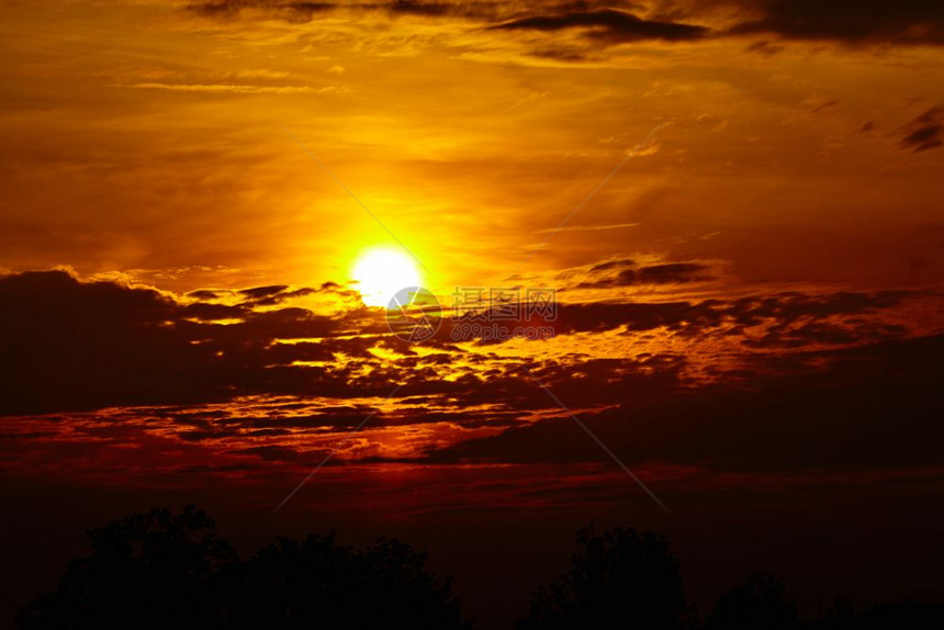 日落时有云的彩色天空金背景图片