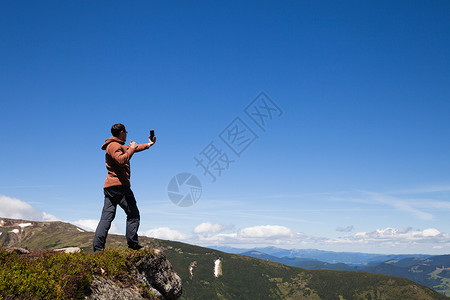 山顶上的人用手机拍自图片