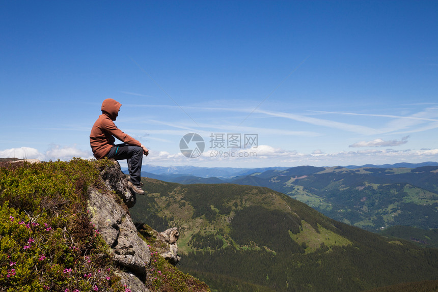 人坐在山顶上仰视地平线图片