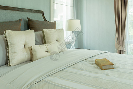 室内舒适有白色枕头和床边桌上的阅读灯图片