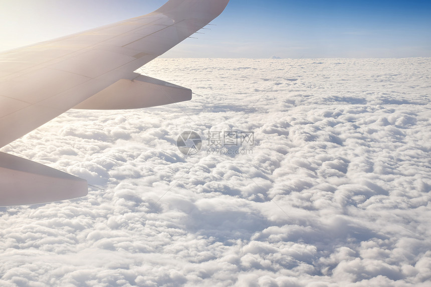 飞机在晴朗的白云中飞行图片