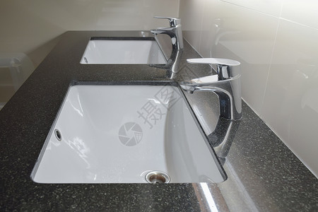 现代式水龙头在厕所的防洗盆下高清图片