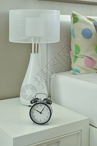 客厅床边桌上的时钟和白灯背景图片