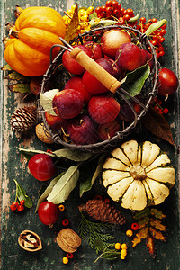 以旧木背景作为篮子和秋装饰的苹果图片