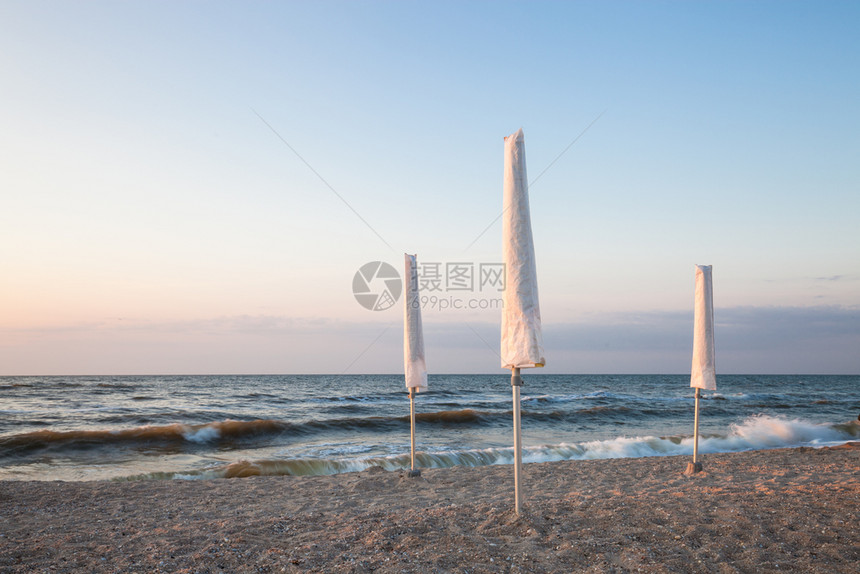 清晨海滩上的白雨伞图片