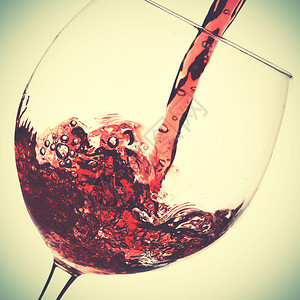红色葡萄酒在玻璃中溢出反向风格过滤图像图片