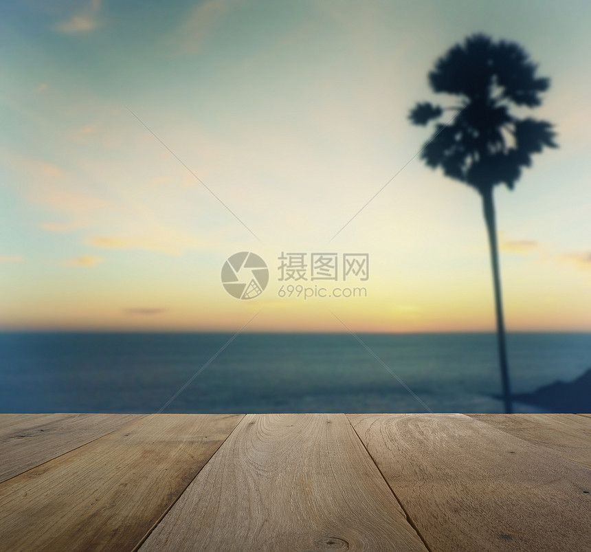热带海滩上树棕榈的浅色日落视图上顶的木板热带海滩上有浅的棕榈树图片