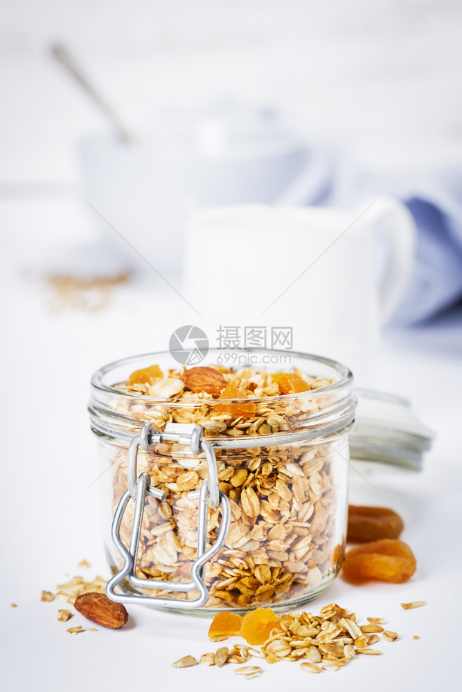 在白色背景的玻璃罐中用水果和坚自制燕麦颗粒片加水果和坚图片