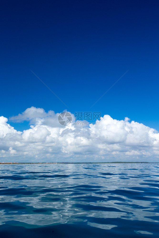 蓝云在平凉的海面上云在蓝的天空上阳光反射图片