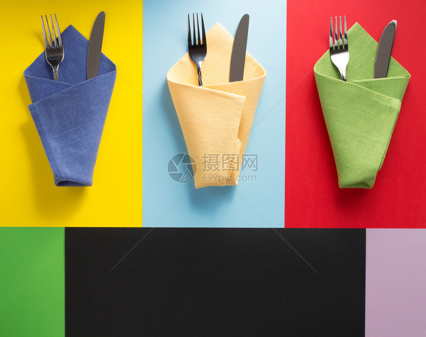 餐巾上的刀叉和背景多彩图片