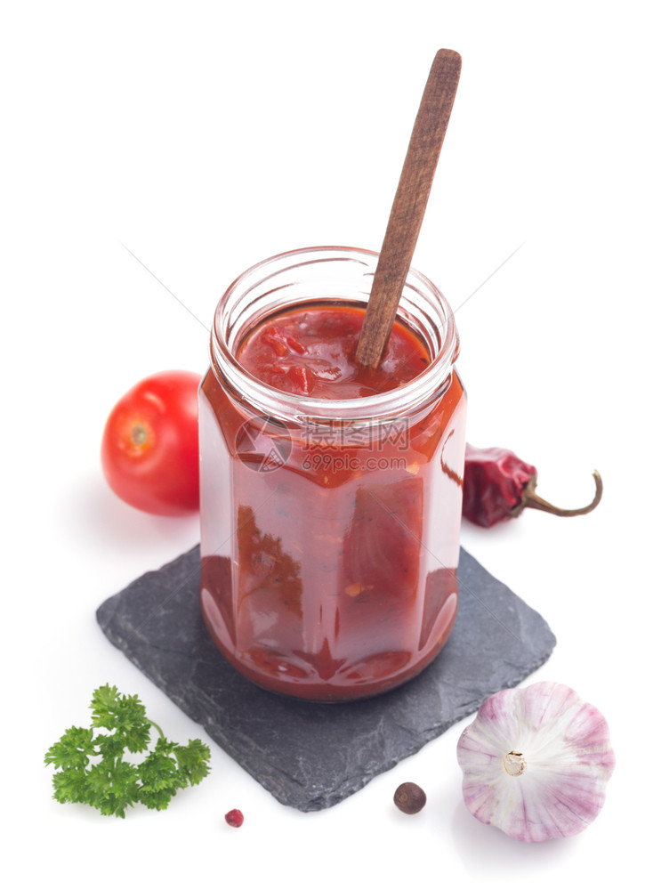 白色背景的玻璃罐中番茄酱图片