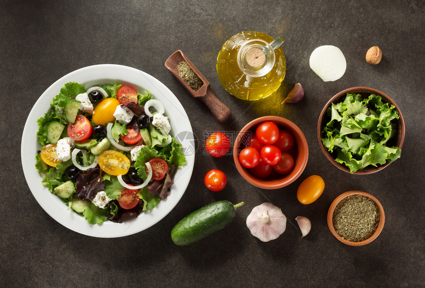 盘中的新鲜希腊沙拉和石桌上的成分图片