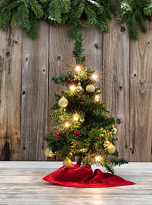 生锈木板上的圣诞树装饰底有常青树枝图片