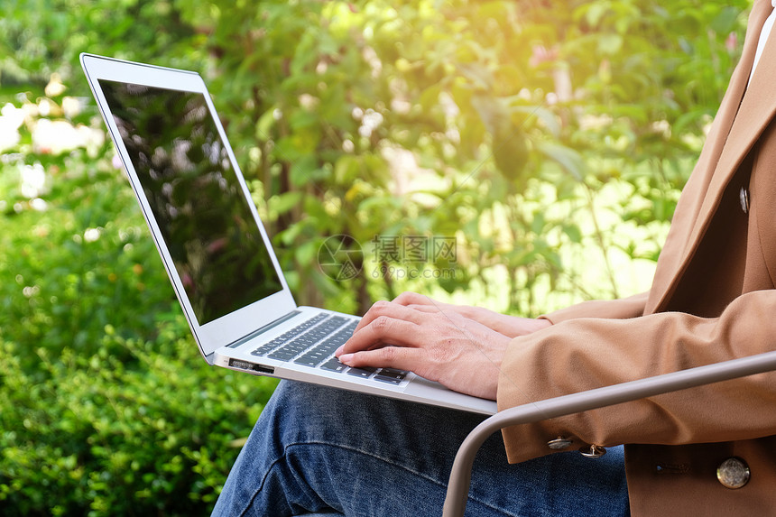 临时工女在网上用笔记本电脑工作笔记本电脑在她家用笔记本电脑屏幕上的键盘打图片