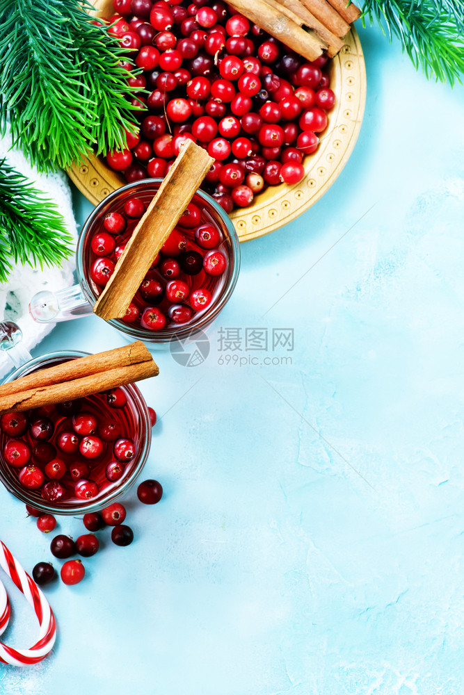 红莓酒和浆果圣诞节喝在玻璃和桌子上图片