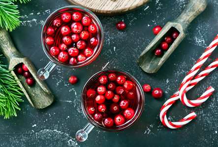 红莓酒和浆果圣诞节喝在玻璃和桌子上图片
