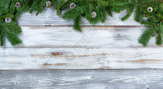 木板展示板边框圣诞树的顶端边框枝和松锥以平整的固定形式在生锈的木头上背景