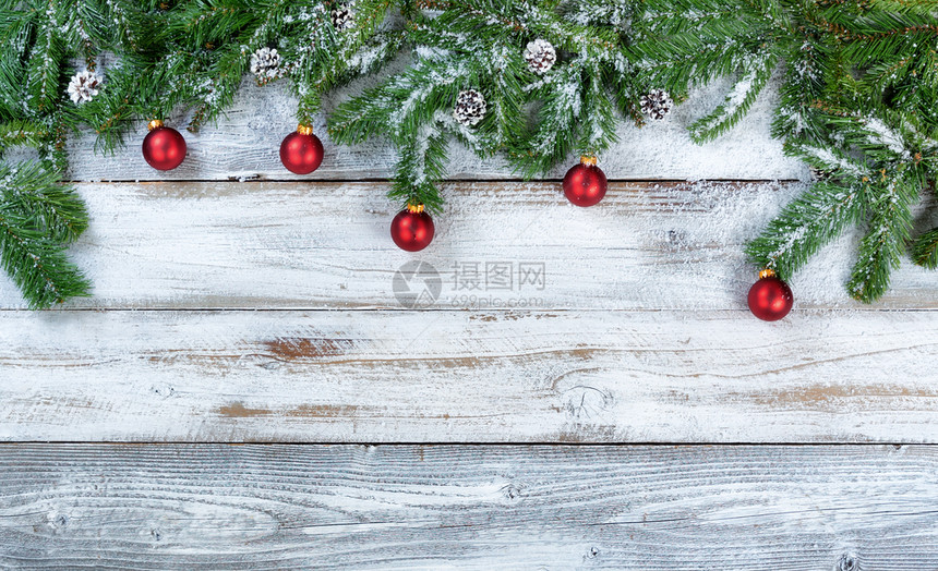 带有传统红球装饰品和松果的红球树枝和松锥在生锈木上以平整的固定形式图片