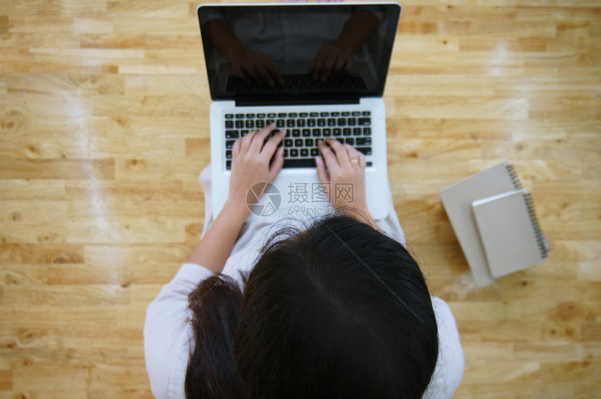 临时工女在网上用笔记本电脑工作笔记本电脑在她家用笔记本电脑屏幕上的键盘打图片