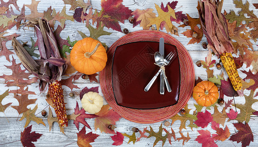 传统的感恩节假日晚宴餐桌设置在有秋天装饰的生动餐桌上图片