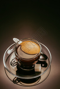 黑光背景的玻璃杯中咖啡图片