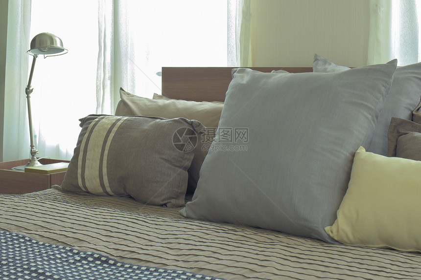 在现代日式本卧室床上铺大小不同单衬枕头图片