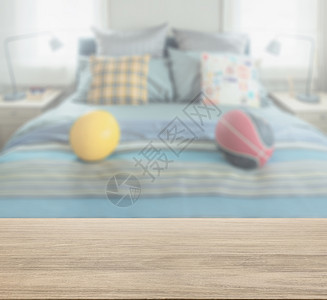 木板桌顶卧室模糊床上装饰枕头和橄榄球背景图片