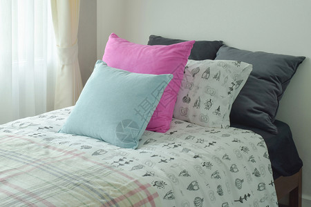 单床大小的浅蓝色和粉红枕头图片