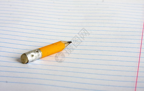 一小根铅笔的躺在一排学校笔记本上的图片
