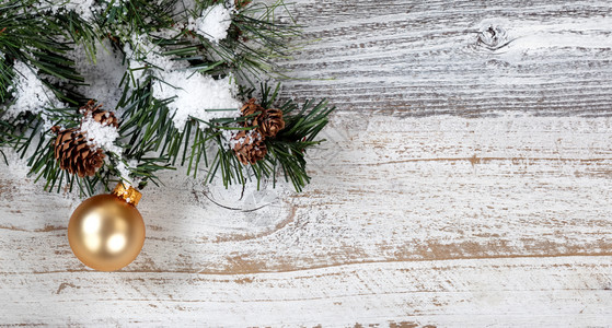 挂在生锈的白色木背景的粗fir树枝上的圣诞金首饰图片