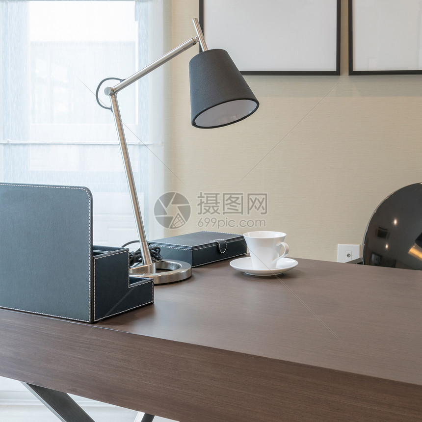 室内现代工作的木制桌配有阅读灯和茶杯的木制桌图片