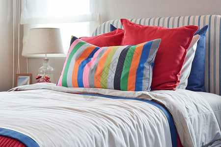彩色条纹折扣板在白床单上挂有彩色枕头和条纹的板上挂有彩色枕头和白床单上挂有条纹枕头背景