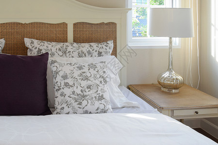 带有花枕头和装饰桌灯的旧卧室内装有花枕头和饰板灯图片