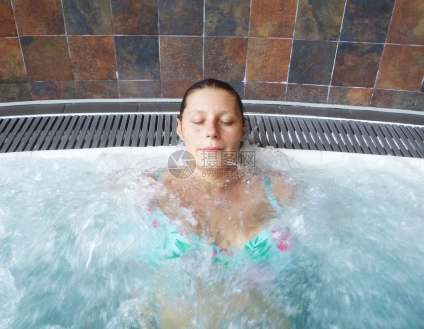 一个放松的女人在美容疗养院做水面按摩图片