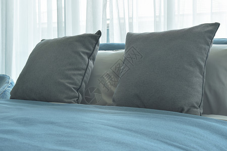 在现代卧室用蓝色毯子铺在床上的灰色枕头和蓝毯子图片