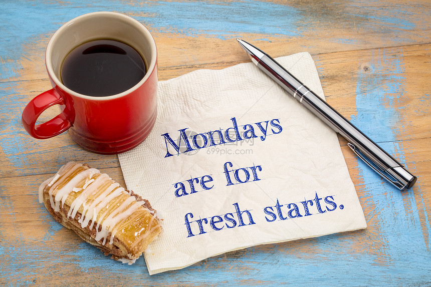 星期一是新开始的星期一手放在餐巾纸上加一杯咖啡和饼干图片