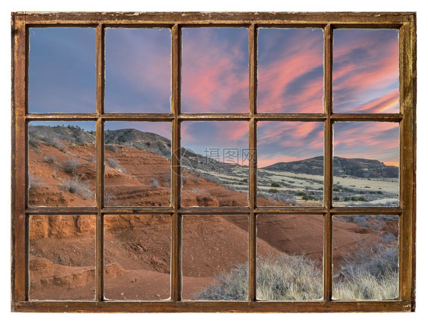 在科罗拉多山丘的沙石峡谷上日落从古老的用脏玻璃遮着的沙窗上图片