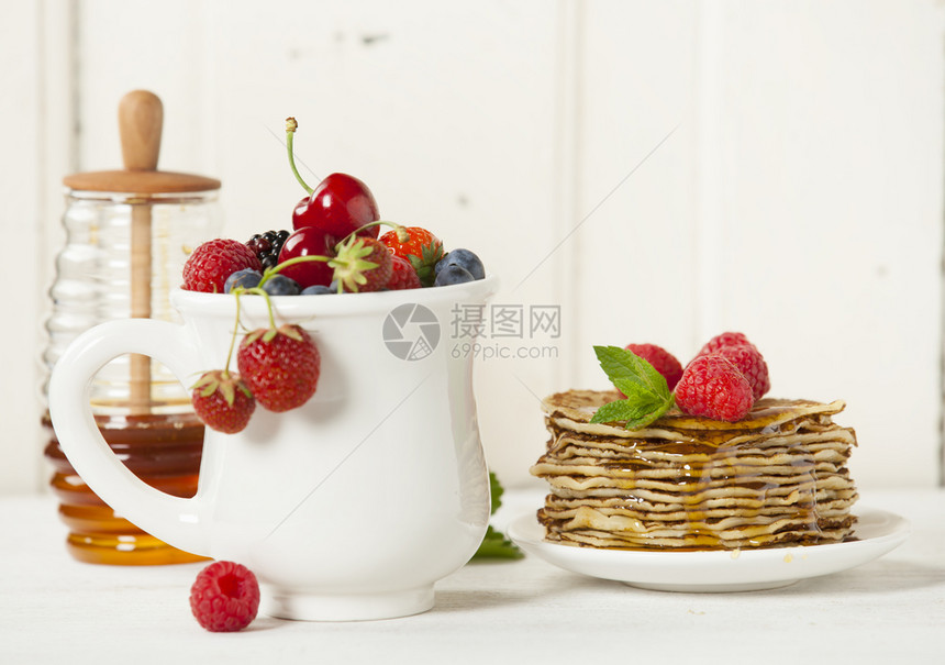 混合浆果和煎饼堆叠着浆果和蜂蜜图片