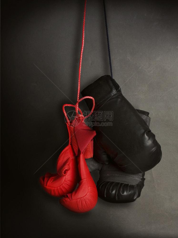 新一对孩子的红手套用于空道的红套和用于在黑暗灰色背景上挂着拳击的老成人手套图片