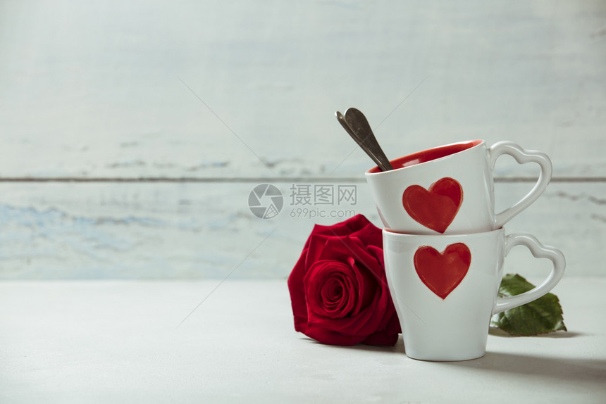 白杯和玫瑰在木质背景上爱或情人节和概念图片