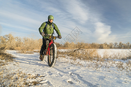 赛手年轻人骑着山地车在科罗拉多寒冷的路面上背景