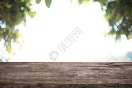 在户外花园灯光的抽象模糊背景面前的木桌图像可用于显示或装配产品图片