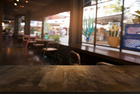 咖啡店的抽象模糊背景面前的空木板可以用来显示产品模版背景图片